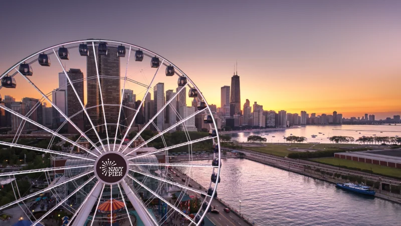 Chicago's Navy Pier at sunset, its iconic ferris wheel in the foreground.